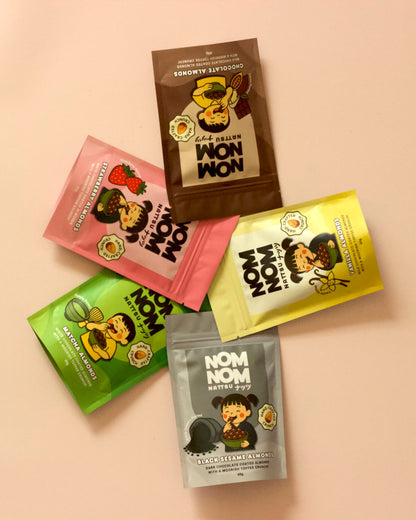 Five colorful 'NOM NOM' snack packages on a beige background
